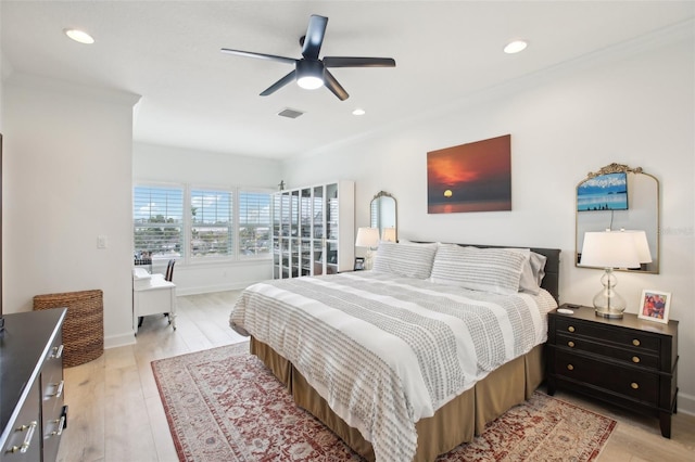 bedroom featuring ceiling fan, light hardwood / wood-style floors, and crown molding