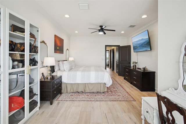 bedroom featuring ceiling fan, ornamental molding, and light hardwood / wood-style floors