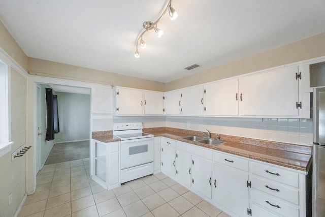 kitchen featuring electric stove, white cabinetry, light tile patterned floors, and sink