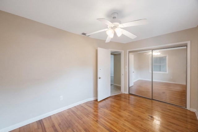 unfurnished bedroom with a closet, light hardwood / wood-style floors, and ceiling fan