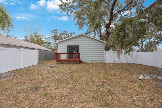 rear view of house featuring a deck and a lawn