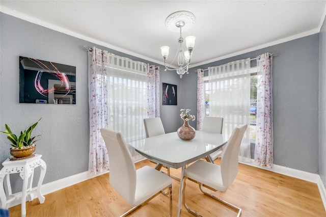 dining room with an inviting chandelier, crown molding, and hardwood / wood-style floors