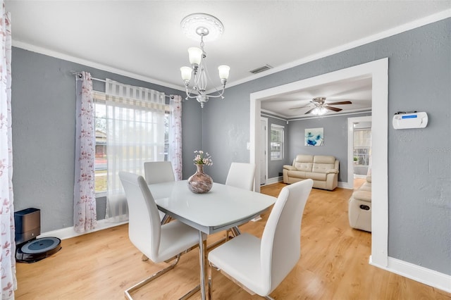 dining space with ceiling fan with notable chandelier, light hardwood / wood-style floors, and crown molding