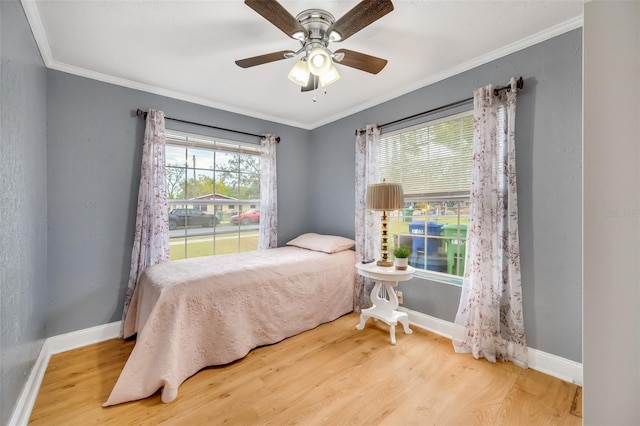 bedroom with wood-type flooring, ceiling fan, and crown molding