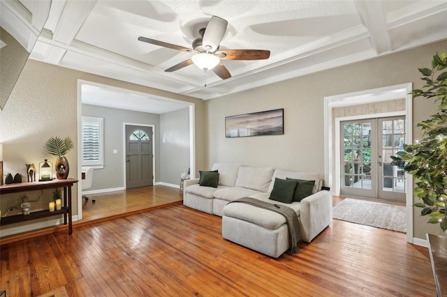 living room featuring wood-type flooring, french doors, and coffered ceiling