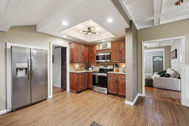 kitchen featuring tasteful backsplash, beam ceiling, appliances with stainless steel finishes, and light hardwood / wood-style flooring