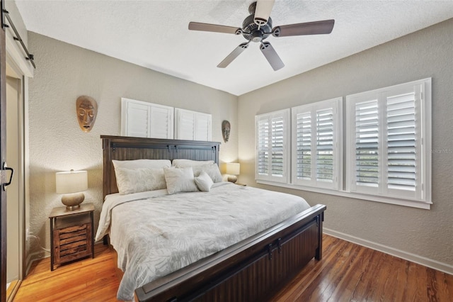 bedroom featuring ceiling fan, hardwood / wood-style flooring, and a barn door