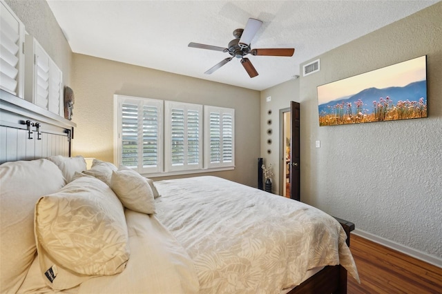 bedroom featuring ceiling fan, a textured ceiling, and hardwood / wood-style flooring