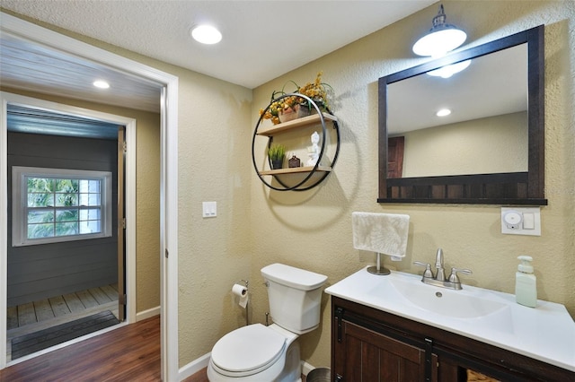 bathroom with toilet, hardwood / wood-style flooring, and vanity