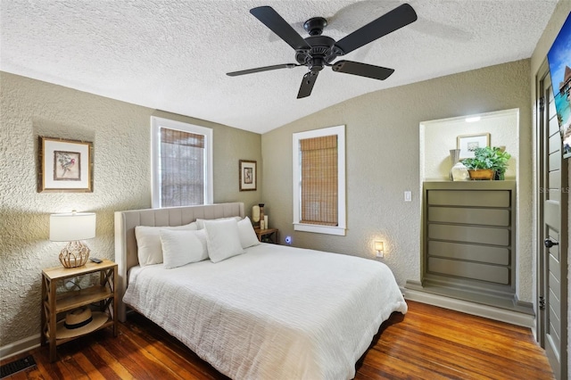 bedroom featuring ceiling fan, a textured ceiling, dark hardwood / wood-style flooring, and lofted ceiling