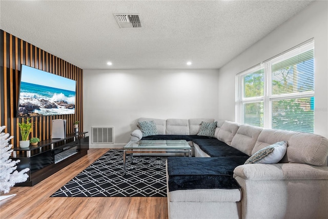 living room featuring wood-type flooring and a textured ceiling