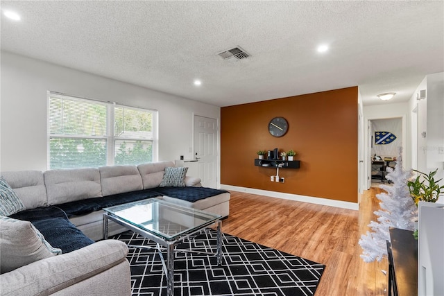 living room with hardwood / wood-style flooring and a textured ceiling