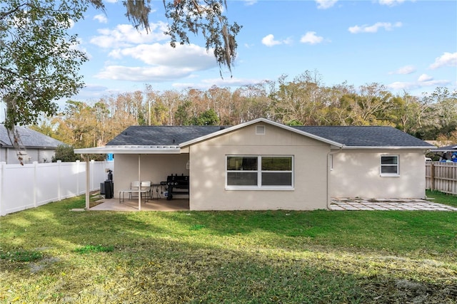 back of house featuring central AC, a patio, and a yard