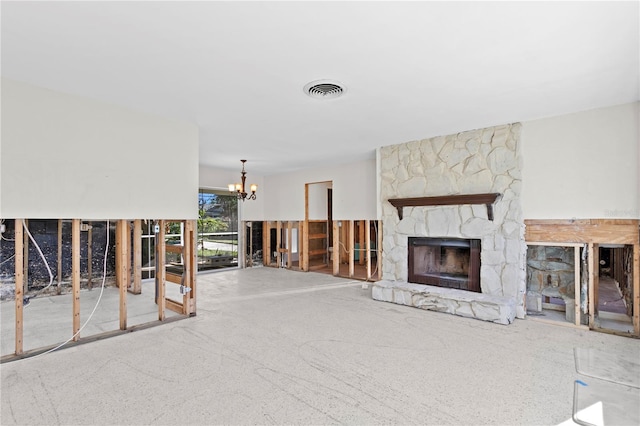 unfurnished living room with an inviting chandelier and a stone fireplace