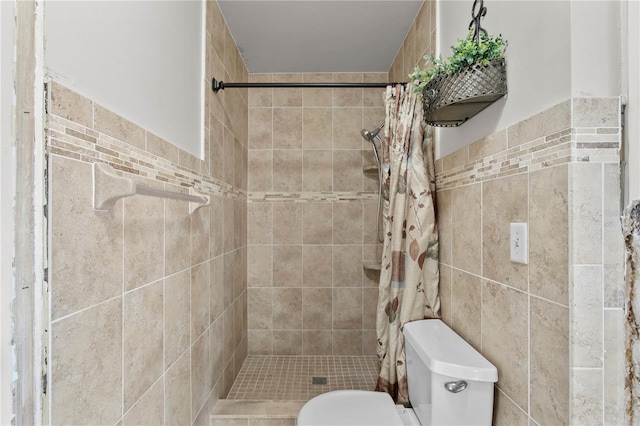 bathroom with toilet, tile walls, and a shower with curtain