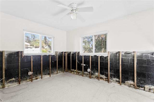 empty room with ceiling fan and plenty of natural light