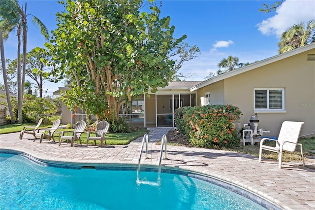 view of pool featuring a sunroom and a patio