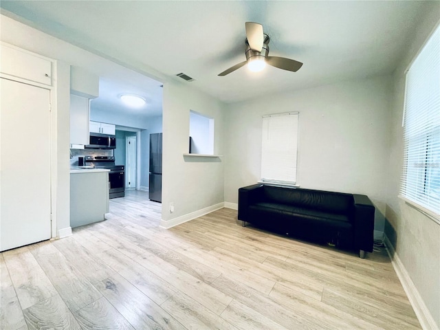 living area with light hardwood / wood-style floors and ceiling fan