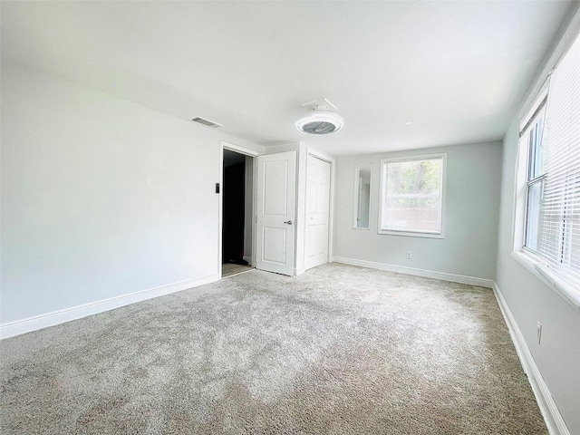 unfurnished bedroom featuring light colored carpet and a closet