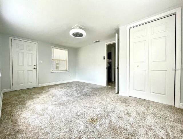 unfurnished bedroom featuring carpet and a closet