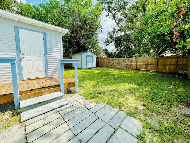 view of yard featuring a wooden deck and a storage unit