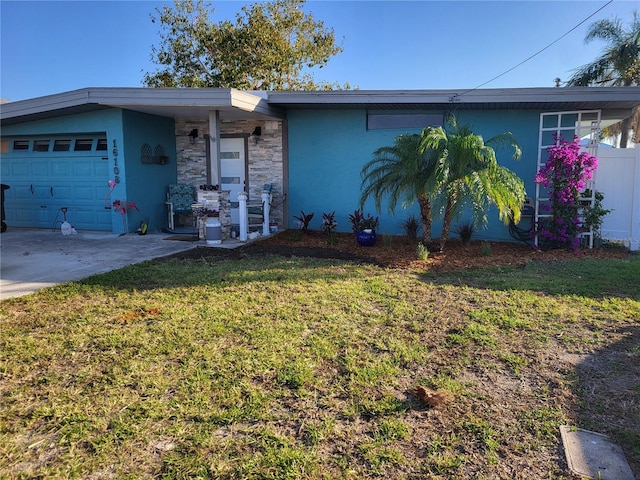 16108 5th St E, Redington Beach, FL 33708 - mid-century home featuring a front yard, an attached garage, and stucco siding