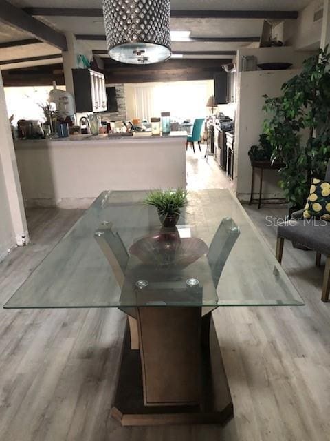 dining space with hardwood / wood-style floors and beamed ceiling