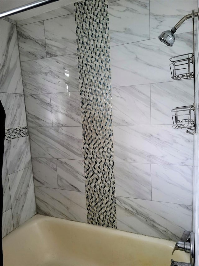 bathroom featuring tiled shower / bath