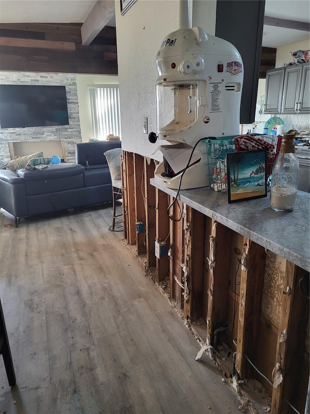 kitchen featuring beamed ceiling and hardwood / wood-style floors