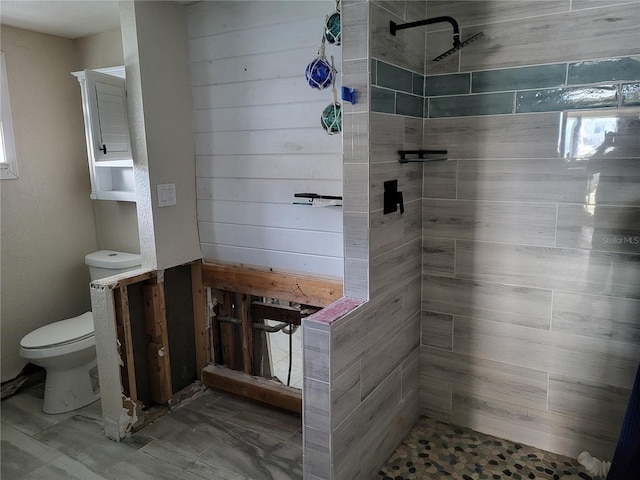 bathroom with toilet and a tile shower