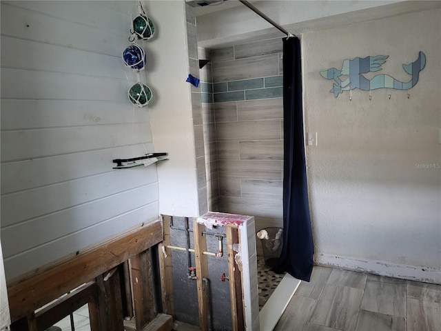 bathroom featuring hardwood / wood-style floors and tiled shower