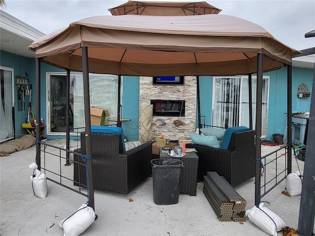 view of patio / terrace featuring a gazebo and an outdoor living space with a fireplace