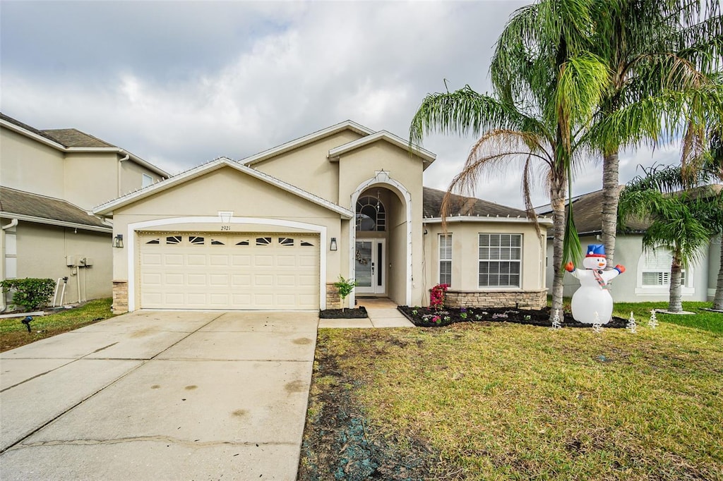 ranch-style house featuring a garage and a front lawn