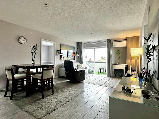 dining area with a wall mounted AC and a textured ceiling