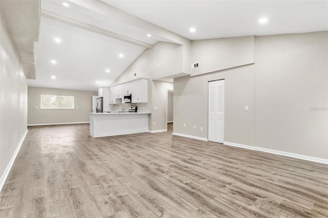 unfurnished living room featuring high vaulted ceiling, beamed ceiling, and light hardwood / wood-style flooring