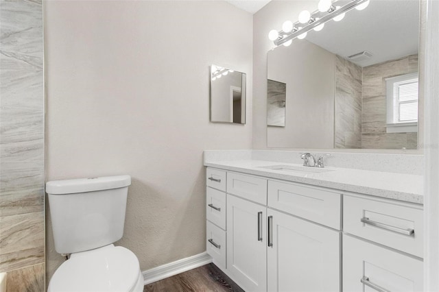 bathroom with wood-type flooring, toilet, and vanity