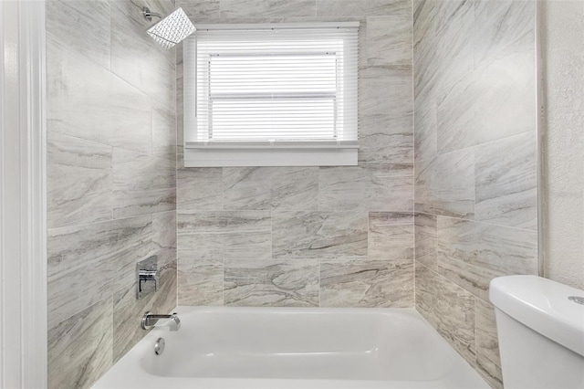 bathroom with toilet and tiled shower / bath