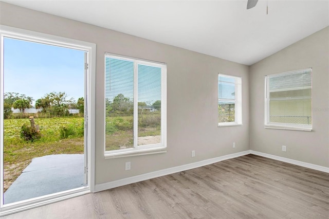 spare room featuring lofted ceiling, ceiling fan, and light hardwood / wood-style flooring