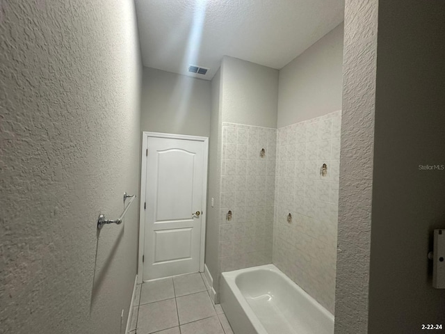 bathroom featuring a textured ceiling, tile patterned flooring, and shower / bathing tub combination