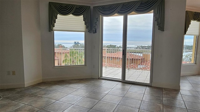 spare room featuring a water view, plenty of natural light, and tile patterned flooring