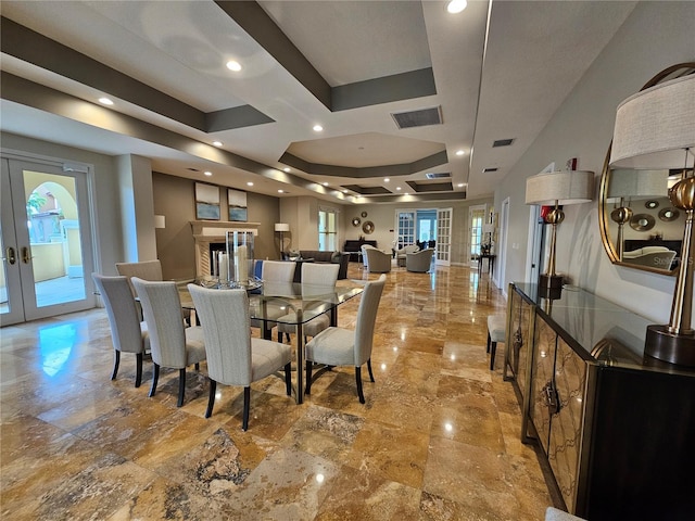 dining area with a raised ceiling and french doors