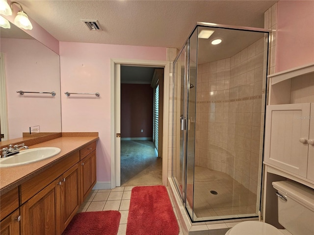 bathroom with tile patterned flooring, an enclosed shower, toilet, a textured ceiling, and vanity