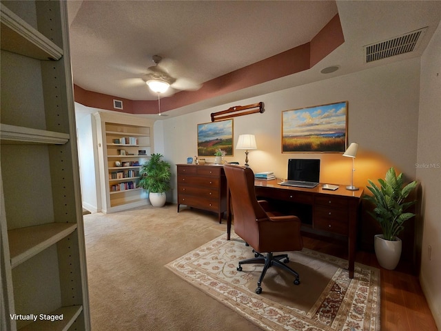 office area featuring ceiling fan, a textured ceiling, built in features, and light wood-type flooring