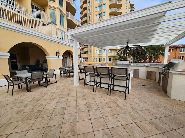 view of patio with ceiling fan, grilling area, exterior bar, and area for grilling