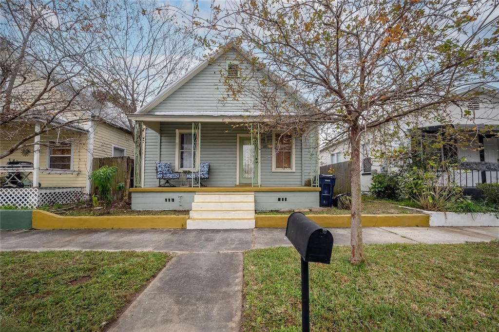 bungalow with a front lawn and a porch