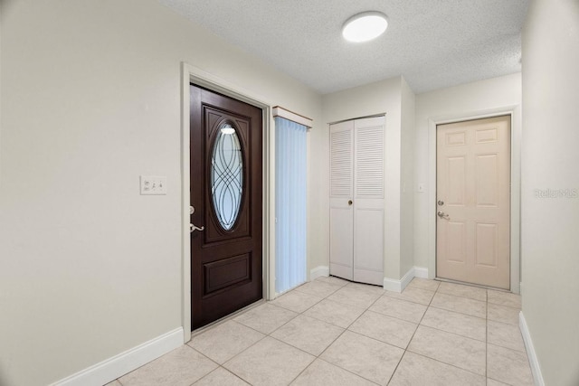 foyer entrance featuring light tile patterned floors and a textured ceiling