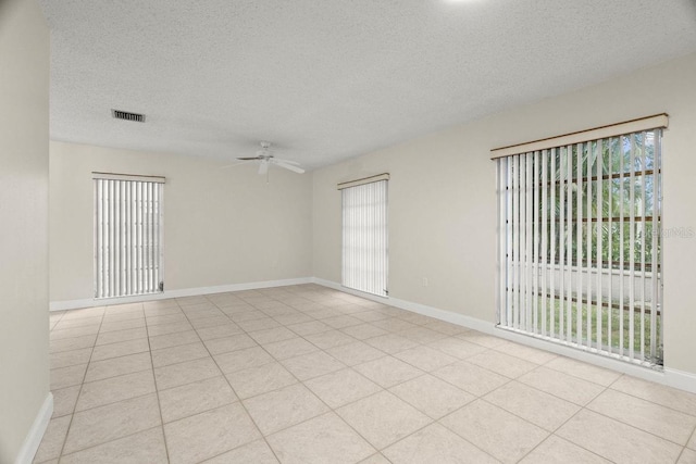 tiled empty room with a textured ceiling and ceiling fan