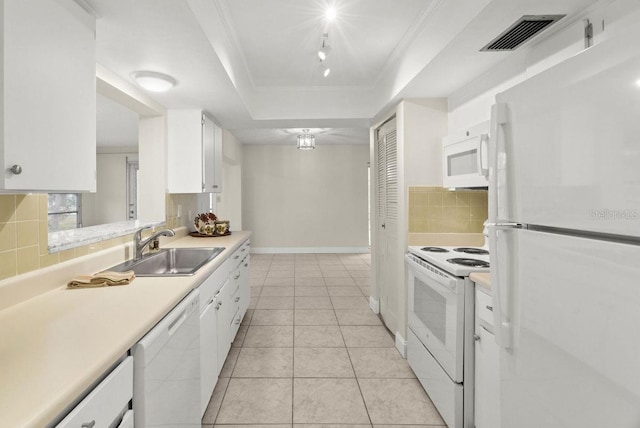 kitchen with sink, white appliances, white cabinetry, ornamental molding, and a raised ceiling