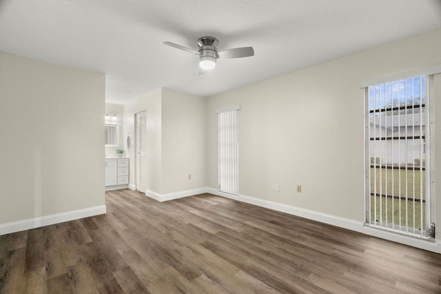 spare room featuring wood-type flooring, a textured ceiling, and ceiling fan