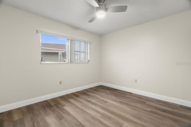 empty room with ceiling fan, hardwood / wood-style flooring, and a textured ceiling